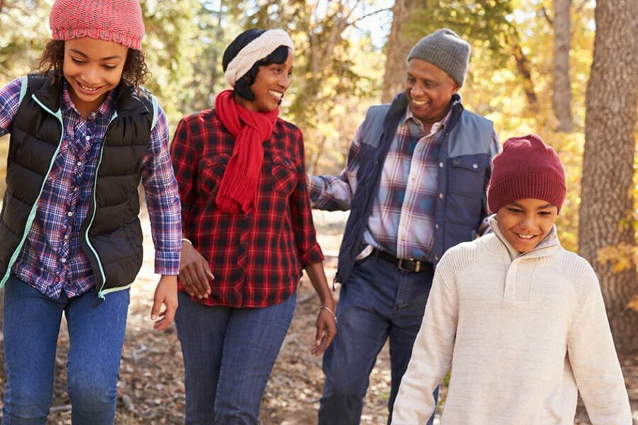 black family of 4 walking in the woods