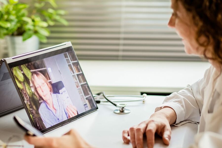 telemedicine concept elderly woman using laptop and taking her blood pressure