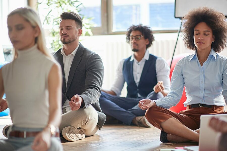 Office workers meditating at work