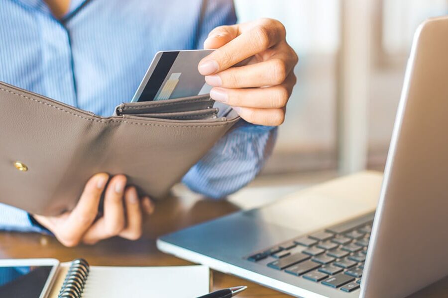 women taking out credit card on wallet to pay off debts