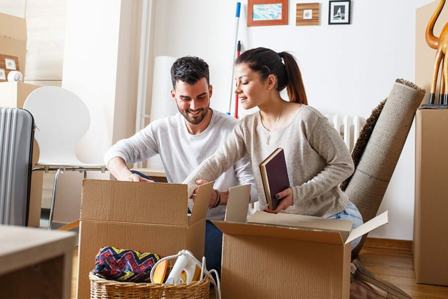 Young couple packing boxing to move new home