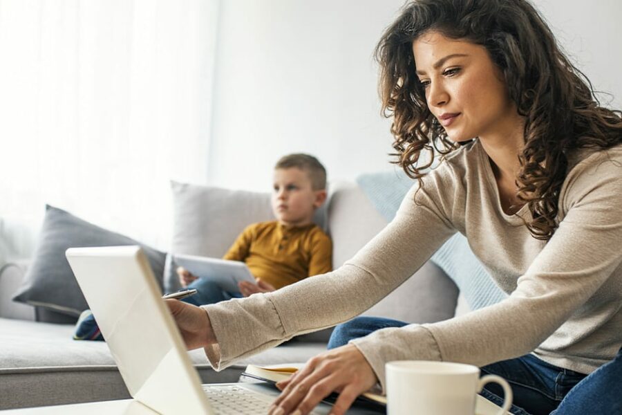 Newly Divorced woman filling tax with his son at the back
