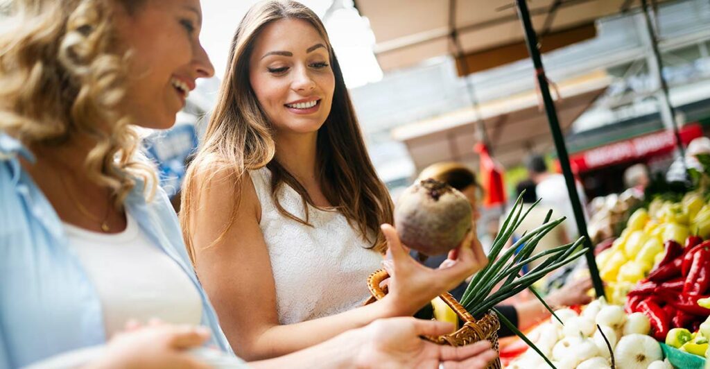 2 women shopping at a farmers market