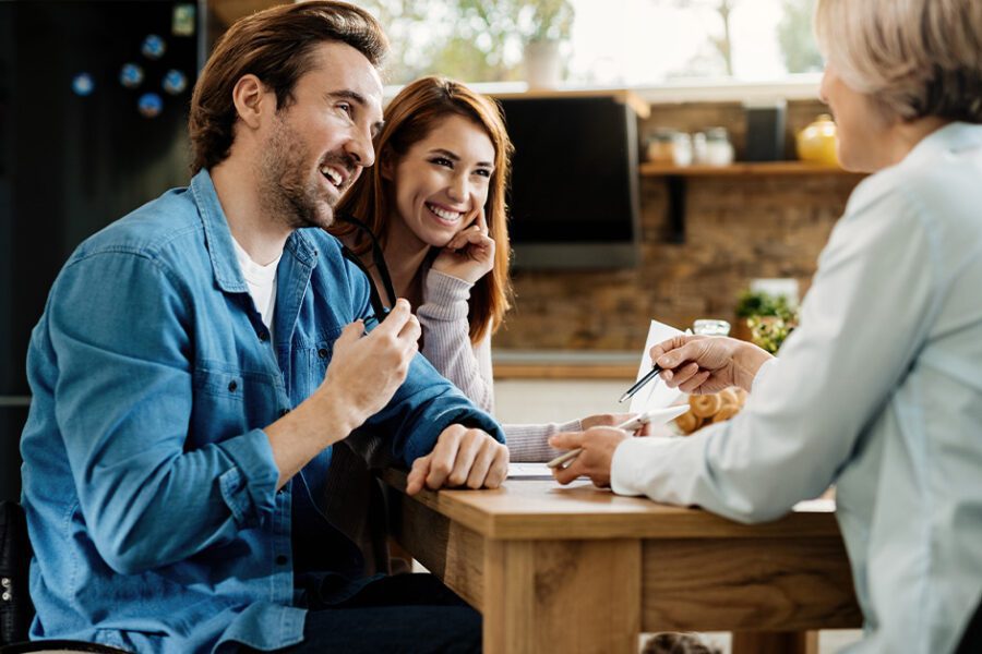 A couple with a man on a wheelchair discussing with an advisor to check his eligibility for life insurance
