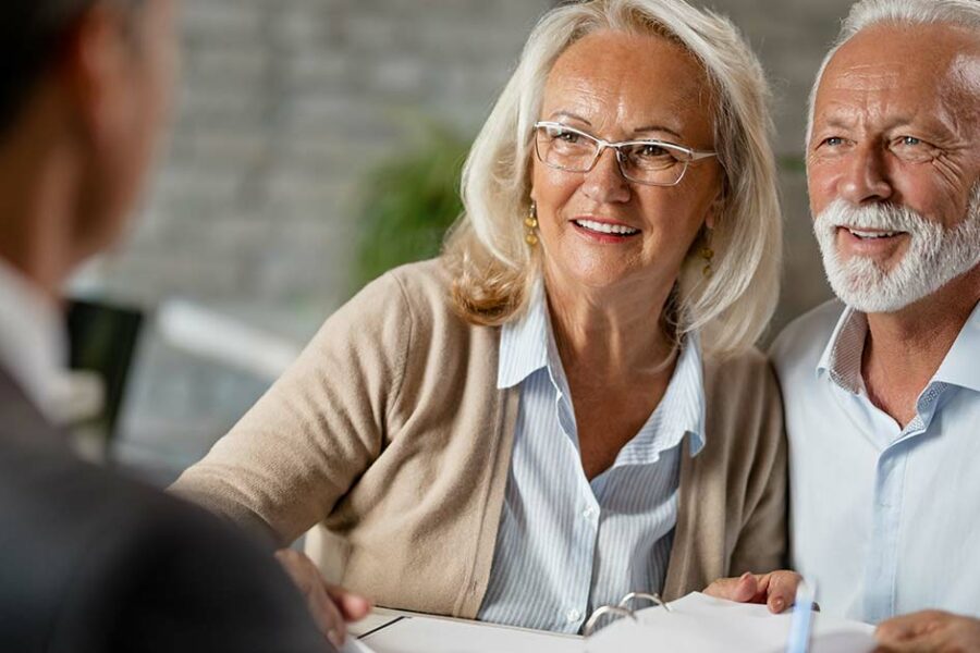 An elderly couple talking to their insurance advisor about estate planning