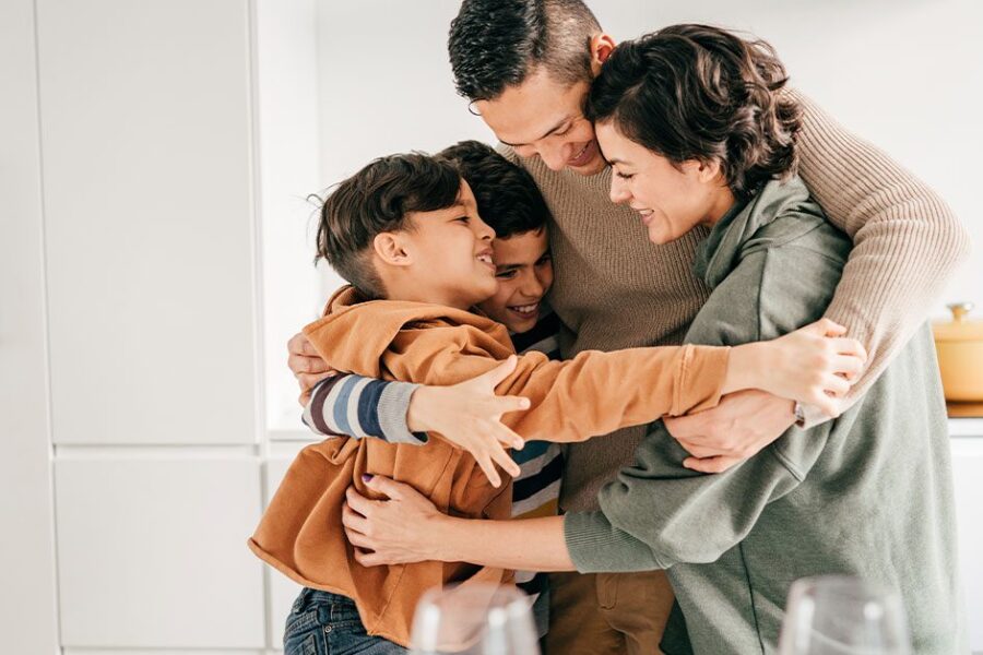 family with 2 kids hugging